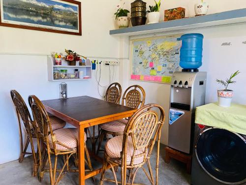 d'une salle à manger avec une table, des chaises et un réfrigérateur. dans l'établissement Experience Tibetan rooms, à Pokhara