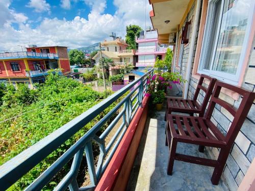 a balcony with a bench and a view of a city at Experience Tibetan Rooms in Pokhara