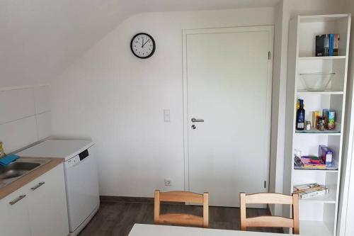 a kitchen with two chairs and a clock on a wall at Dachwohnung Eyb mit 3 Schlafzimmern in Ansbach