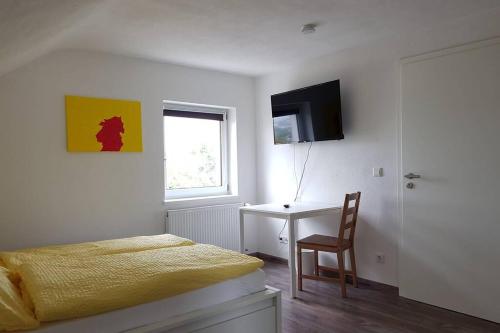 a bedroom with a bed and a desk and a television at Dachwohnung Eyb mit 3 Schlafzimmern in Ansbach