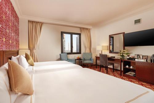 a hotel room with a large bed and a desk at Dallah Taibah Hotel in Al Madinah