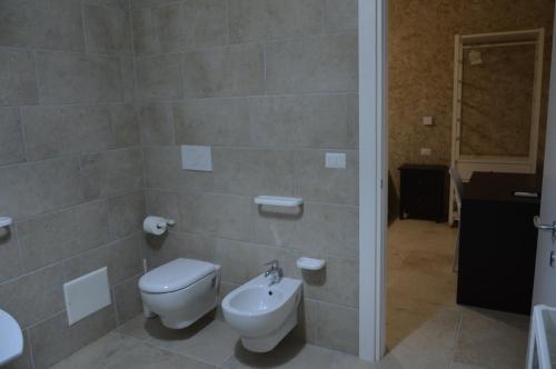 a bathroom with a toilet and a sink at B&B Poseidon in Punta Prosciutto