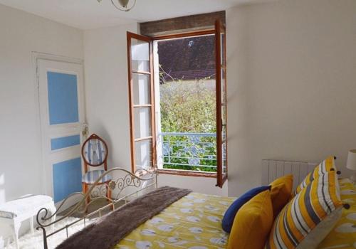 Schlafzimmer mit einem Bett und einem Fenster in der Unterkunft Chez Claire in Excideuil