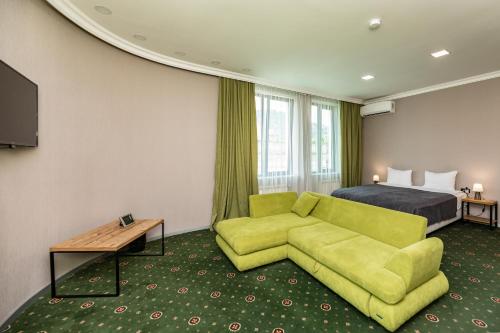 a hotel room with a green couch and a bed at Old Side Corner in Tbilisi City