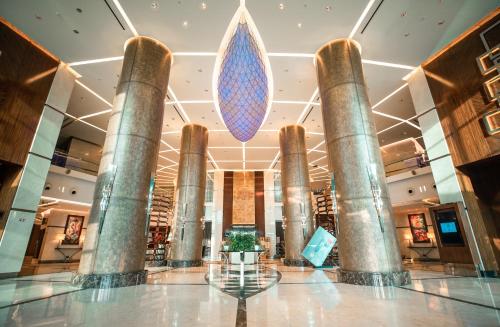 a lobby of a hotel with columns and a large blue drop at FLY INN BAKU in Baku