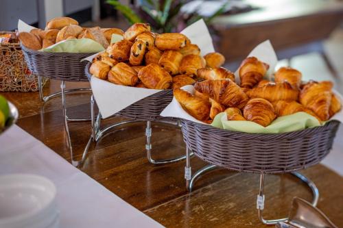 dos cestas llenas de diferentes tipos de pan en una mesa en Logis Hotel Noemys pont de l'Etoile, en Aubagne