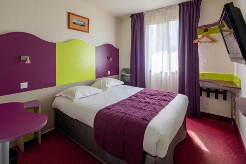 - une chambre avec un lit violet et vert dans l'établissement Logis Hotel Noemys pont de l'Etoile, à Aubagne