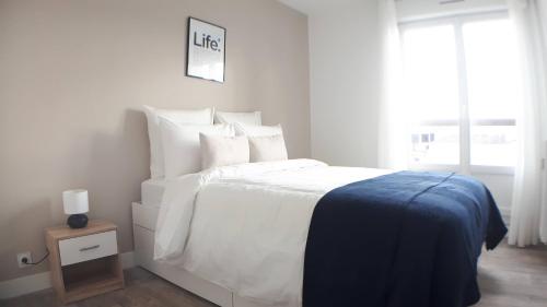 een witte slaapkamer met een groot bed en een raam bij CasaCity Orléans Sud - 2 chambres - parking privé in Orléans