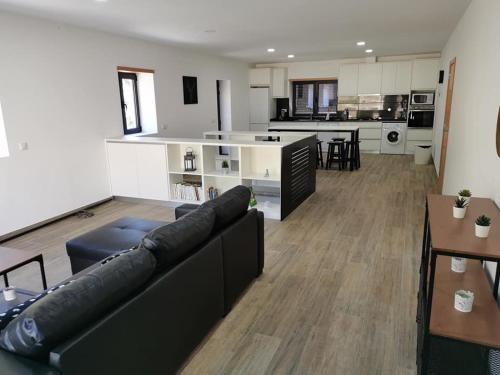 a living room with a couch and a kitchen at casa do mestre in Vieira do Minho