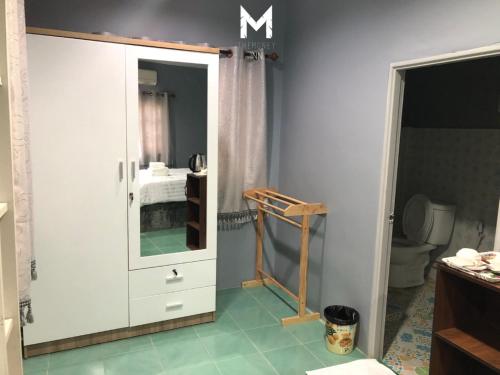 a bathroom with a white cabinet and a toilet at The Money Inn in Khon Kaen
