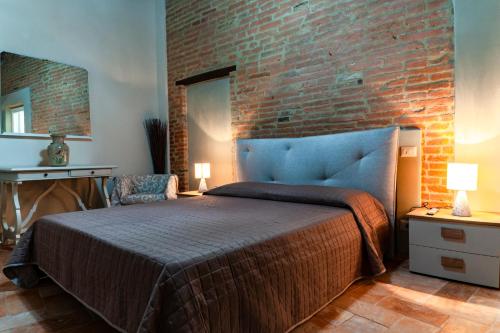 a bedroom with a bed and a brick wall at La casa del Prete in Montecastrilli