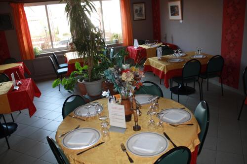 une salle à manger avec des tables, des chaises et un tissu de table rouge dans l'établissement La Renaissance, à Arlanc
