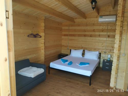 a bedroom with a white bed and a couch at Lazurny in Gagra