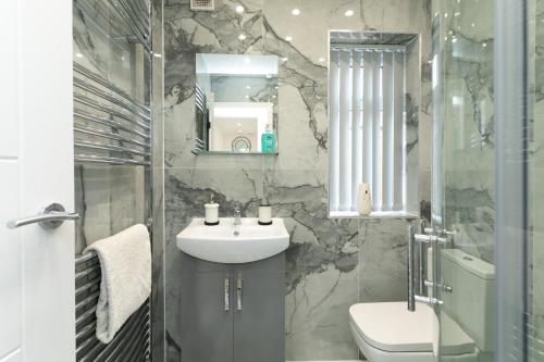 ein Badezimmer mit Waschbecken, Toilette und Spiegel in der Unterkunft Nottingham Serviced Accommodations in Nottingham