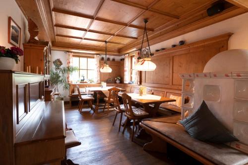 eine Küche und ein Esszimmer mit Tischen und Stühlen in der Unterkunft Hotel Allgäuer Hof in Oberstaufen