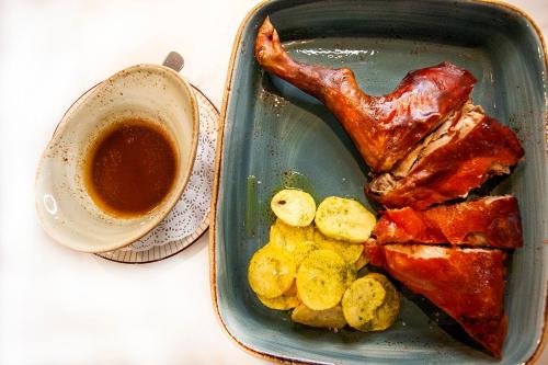a tray of food with a piece of meat and a cup of coffee at Hotel Alfonso VIII in Soria