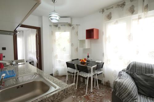 Una cocina con fregadero y una mesa con sillas. en Apartamento Castillo, en Granada