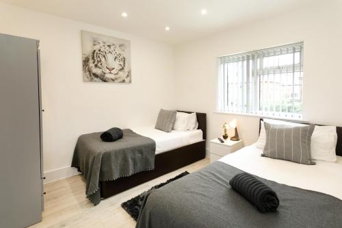zwei Betten in einem Zimmer mit weißen Wänden in der Unterkunft Nottingham Serviced Accommodations in Nottingham