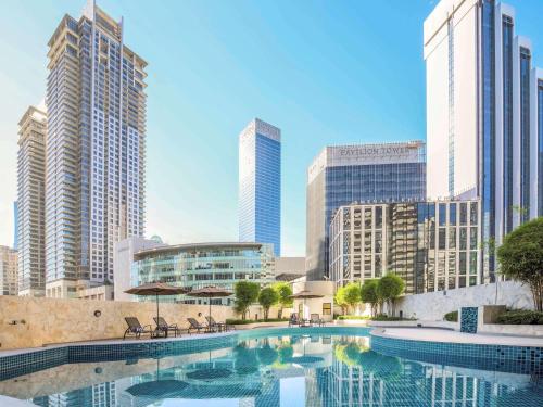 a swimming pool in a city with tall buildings at Novotel Kuala Lumpur City Centre in Kuala Lumpur