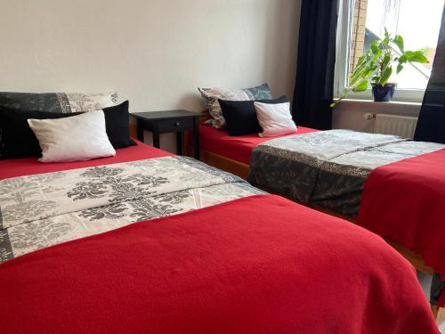 a room with two beds with red covers and a window at FeWo Zum Panscheberg in Salzgitter