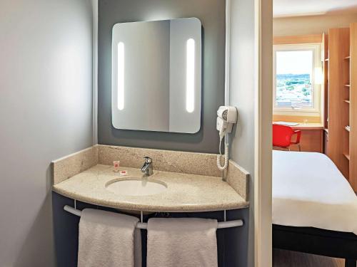La salle de bains est pourvue d'un lavabo avec miroir et d'un lit. dans l'établissement ibis Rio Branco, à Rio Branco