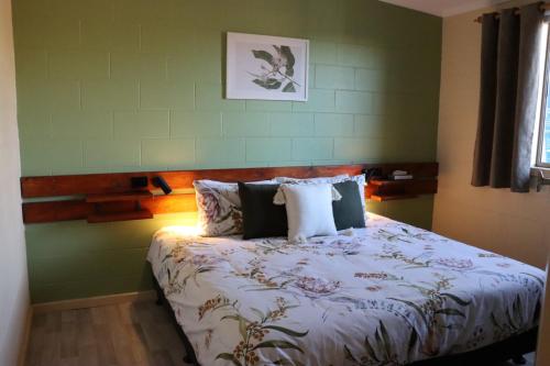 ein Bett in einem Schlafzimmer mit grünen Wänden in der Unterkunft Stay and Relax in Barmera