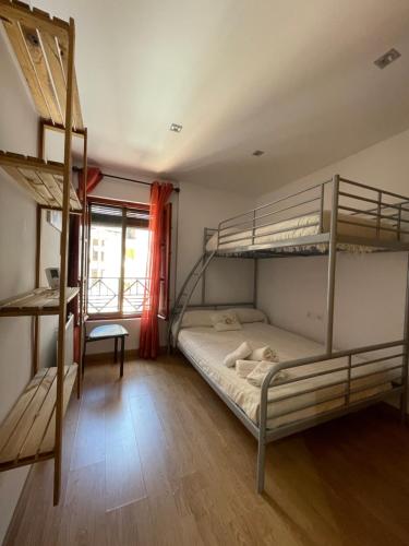 a bedroom with two bunk beds and a desk at Casa rural Los Abuelos in Monachil