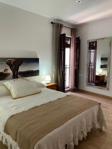 a bedroom with a large bed with a painting on the wall at Casa rural Los Abuelos in Monachil