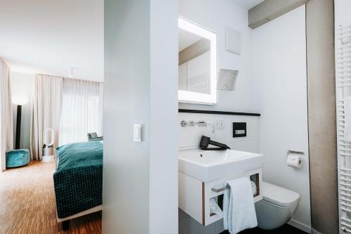 ein weißes Bad mit einem Waschbecken und einem WC in der Unterkunft Abbate Boutique Hotel in Ulm