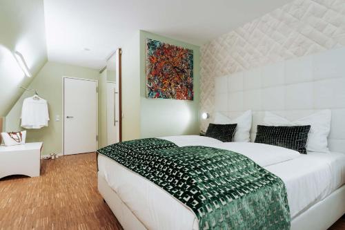a bedroom with a large white bed and a painting at Abbate Boutique Hotel in Ulm