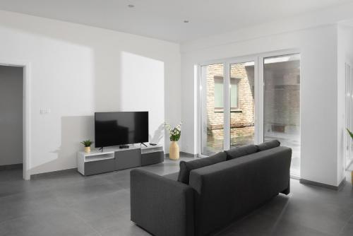 a living room with a couch and a flat screen tv at Appart-Hotel Léopold Liège Centre in Liège