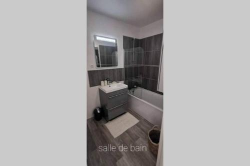 a bathroom with a bath tub and a sink and a bath tub at Idéal famille et couple , vue mer residence calme in Fécamp