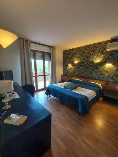 a bedroom with a bed and a couch in a room at EcoHotel Ristorante Milano in Borgo a Mozzano