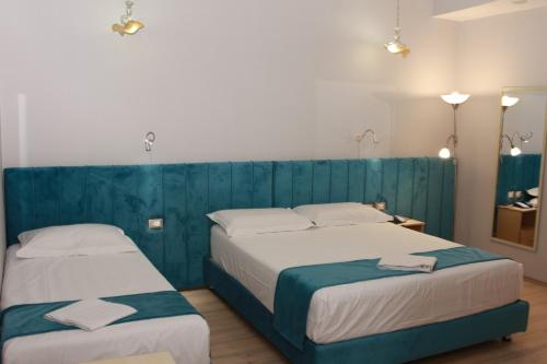 twee bedden in een kamer met blauw en wit bij Theranda Boutique Hotel in Tirana