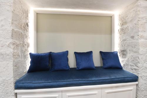a blue bench with three blue pillows on it at Palazzo degli Stemmi in Todi