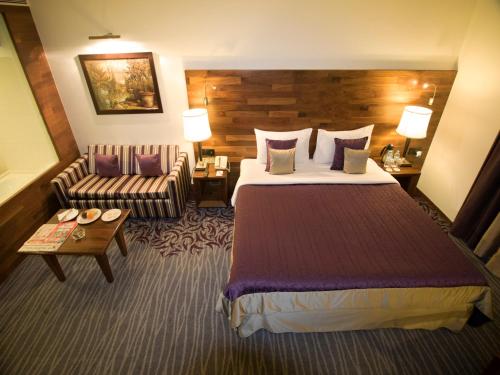 a hotel room with a bed and a couch at The Orchid Hotel Hinjewadi Pune in Pune