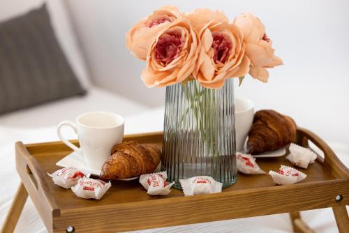 un jarrón con flores en una mesa con pasteles en Apartamenty Nadbrzeżna 250 m do Plaży by Renters en Gąski