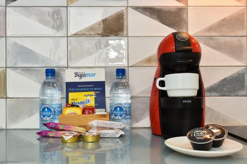 a coffee maker on a counter next to bottles of water at Hotel Apartamento Bajamar in Las Palmas de Gran Canaria