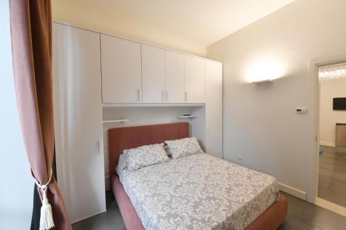 a small bedroom with a bed and white cabinets at Palazzo degli Stemmi in Todi