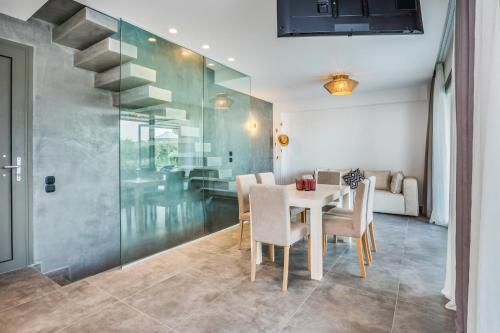 a dining room with a table and chairs and a staircase at Dionisos Luxury Villas in Pefkohori