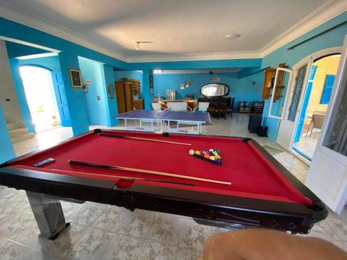 a red pool table in a room with blue walls at Blue House in Alexandria