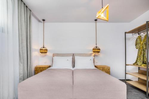 a bedroom with a large bed with two white pillows at Dionisos Luxury Villas in Pefkohori