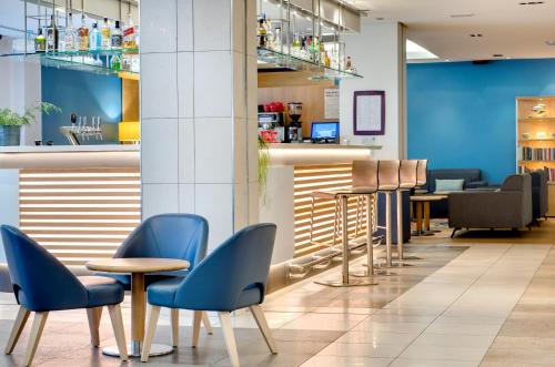a waiting area with blue chairs and tables at Hôtel Padoue in Lourdes
