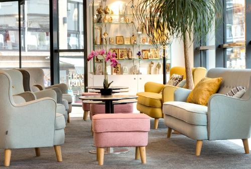 a waiting room with chairs and a table and a shelf at Hôtel Padoue in Lourdes