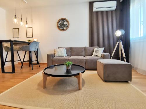 salon z kanapą i stołem w obiekcie Design Apartment at CITY QUART w mieście Podgorica