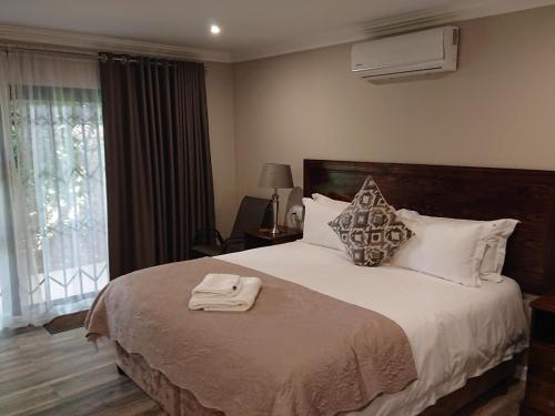 a bedroom with a large bed and a window at Unitas Guesthouse in Centurion