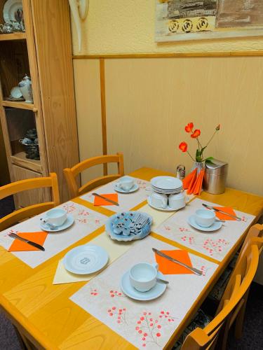 a wooden table with plates and utensils on it at Hotel am Freihafen in Duisburg