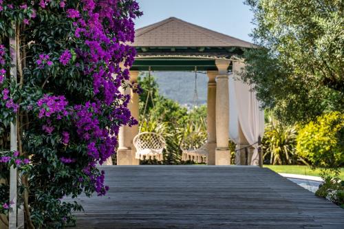 a boardwalk leading to a gazebo with purple flowers at Rinoterra Minho in Caminha