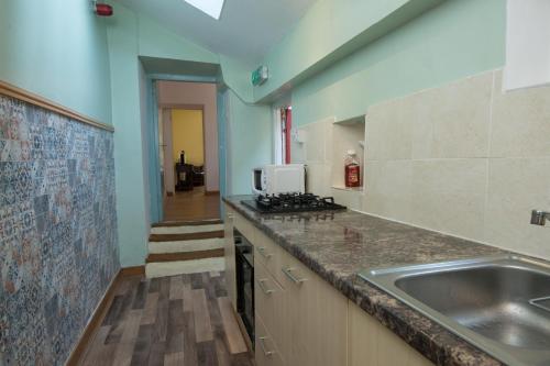 a kitchen with a sink and a counter top at 7 Bedroom Townhouse in Edinburgh