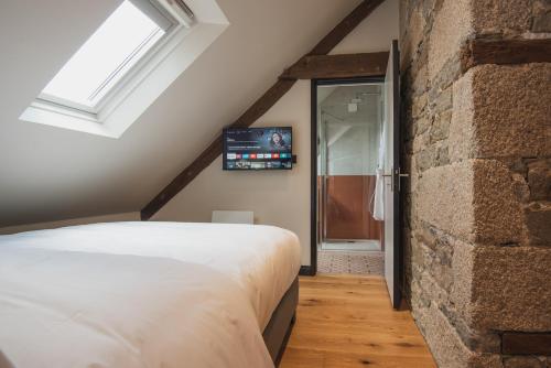 a bedroom with a bed and a brick wall at Luxury cosy family nest in the medieval town in Dinan